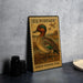 A U.S. postage stamp featuring a green-winged teal duck, placed on a gray countertop next to some black camera lenses.