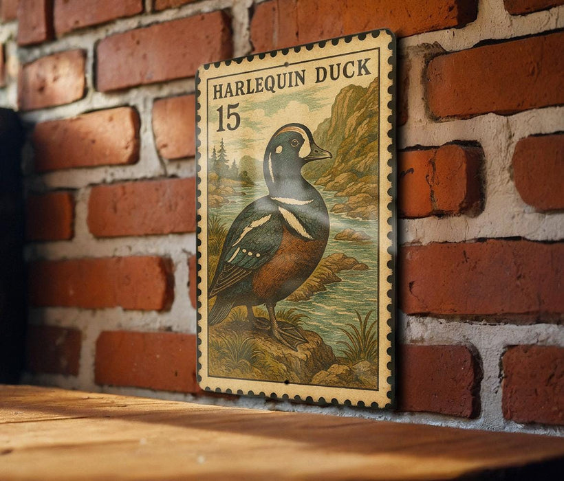 A vintage postage stamp featuring a harlequin duck is displayed on a brick wall.