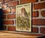 A vintage-style postage stamp featuring a red finch perched on a branch, mounted on a brick wall.