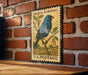 A vintage-style postage stamp featuring a blue bird perched on a branch, mounted on a brick wall.