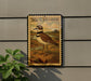 A postage stamp featuring a bird, likely a killdeer, is displayed on a wall.