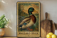 A framed illustration of a Mallard duck is displayed on a shelf, accompanied by a wooden cutting board, a potted plant, and some lemons.