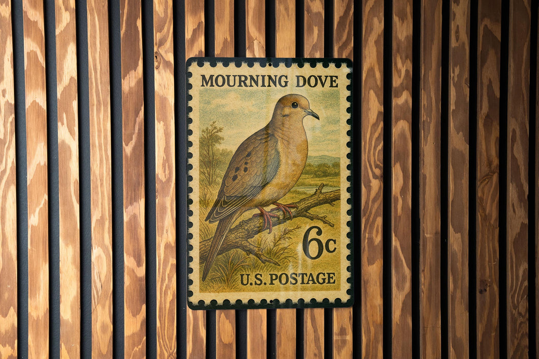 A U.S. postage stamp featuring a mourning dove perched on a branch.