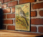 A vintage postage stamp featuring a bird, likely a northern mockingbird, is displayed on a brick wall.