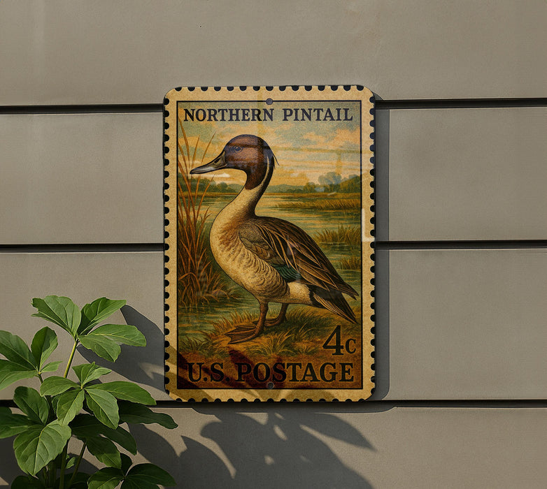 A postage stamp featuring a duck is displayed on a wall, with a plant visible to the left.