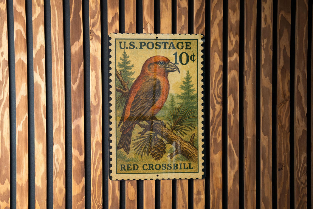A U.S. postage stamp featuring a red bird perched on a pine tree branch, with the text "U.S. POSTAGE 10¢" and "RED CROSSBILL" printed on it.