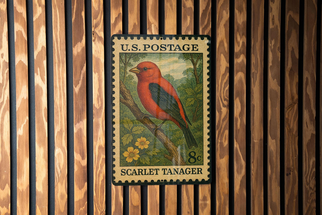 A U.S. postage stamp featuring a red bird, specifically a red-headed tanager, perched on a branch.