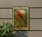 A postage stamp featuring a red bird, likely a scarlet tanager, perched on a branch.