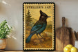 A framed illustration of a blue bird, likely a jay, is displayed on a shelf next to a wooden cutting board and some lemons.
