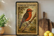 a framed illustration of a red-headed bird perched on a branch, with a vintage-style border.