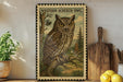 A framed illustration of a Western Screech Owl is displayed on a shelf, accompanied by a wooden cutting board, a potted plant, and some lemons.