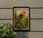a Western Tanager bird perched on a branch, with a stamp-like border around it.