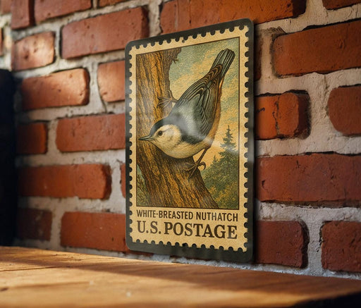 A vintage postage stamp featuring a white-breasted nuthatch is displayed on a brick wall.