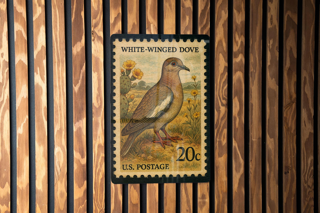 A U.S. postage stamp featuring a white-winged dove, with a wooden fence in the background.
