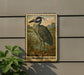 A framed illustration of a yellow-crowned night heron is displayed on a wall, with a plant to the left.