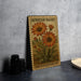 A framed illustration of an African daisy plant on a wall, with a vintage-style stamp design.