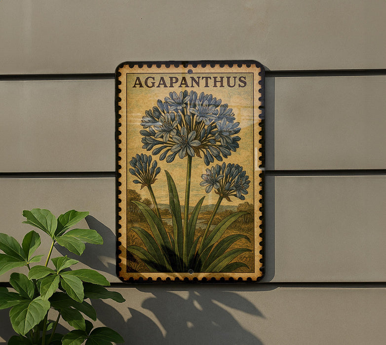 a framed illustration of blue flowers on a wall, with a plant to the left of the frame.
