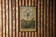 A framed illustration of a flower, specifically an Agapanthus, is displayed on a wooden wall.