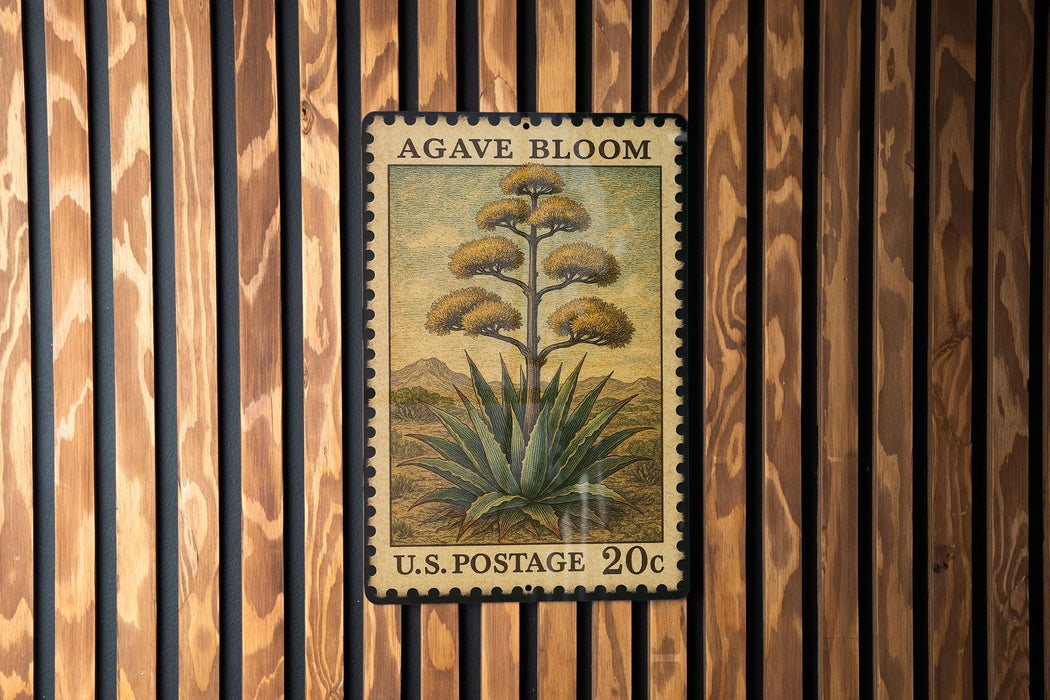 A U.S. postage stamp featuring an illustration of an agave plant, mounted on a wooden wall.