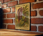 a vintage-style stamp with a plant illustration, mounted on a brick wall.
