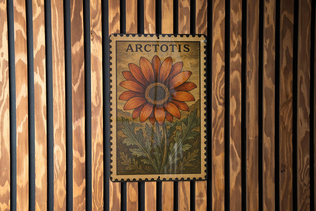 A framed image of a large orange flower with green leaves, mounted on a wooden wall.