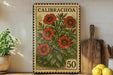 a vintage-style stamp with a floral design, placed on a shelf next to a wooden cutting board and some potted plants.