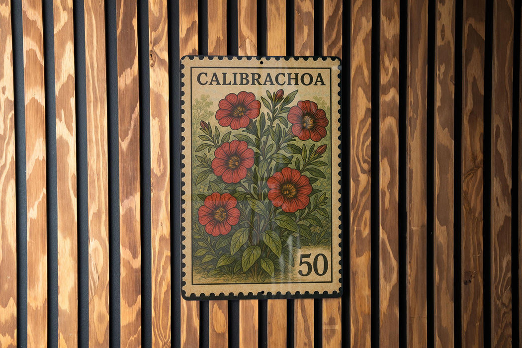 A vintage postage stamp from Calibracha, featuring a floral design with red flowers and green leaves, is displayed on a wooden wall.
