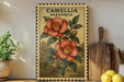 a framed illustration of a red flower on a wooden shelf, with a potted plant to the left and a wooden cutting board to the right.
