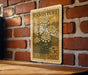 A vintage U.S. postage stamp featuring a floral design is displayed on a brick wall.