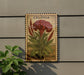 a decorative metal sign with a detailed illustration of a red flower and green leaves, mounted on a wall.