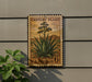 A postage stamp featuring an illustration of an agave plant, mounted on a wall.