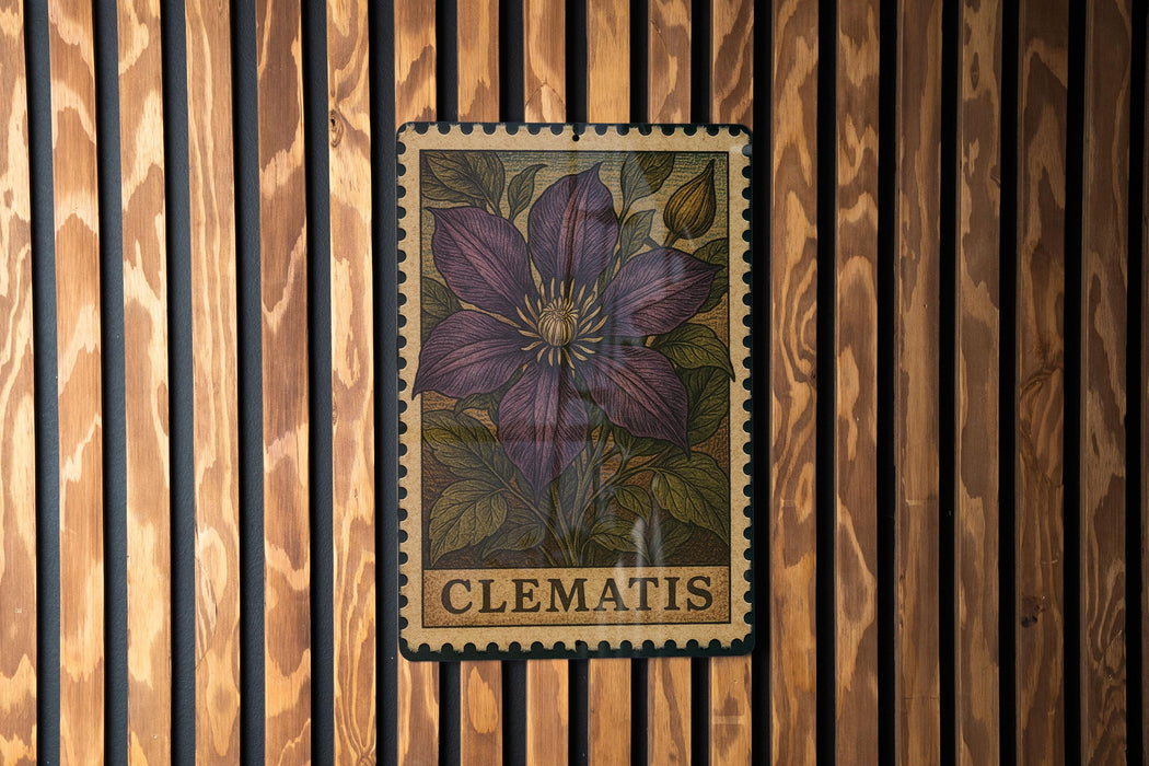 A framed image of a purple clematis flower is displayed on a wooden wall.