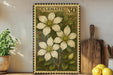 A framed print of a Clematis flower is displayed on a shelf, surrounded by kitchen utensils and a potted plant.
