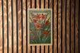 A vintage postage stamp featuring a floral illustration of crocosmia flowers is displayed on a wooden wall.