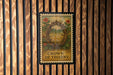 A framed poster with a crown of thorns design is hanging on a wooden wall.