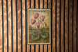 A vintage postage stamp featuring a floral illustration of pink flowers against a natural background.
