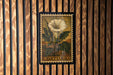 A framed image of a white flower with green leaves, mounted on a wooden wall.