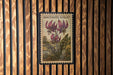 A vintage-style postage stamp featuring a floral illustration of purple flowers, with the text "DOGTOOTH VIOLET" printed on it.