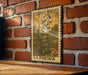 A vintage postage stamp featuring a floral design is displayed on a brick wall.