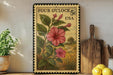 A framed image of a pink hibiscus flower on a wooden shelf, with a wooden cutting board and a lemon in the foreground.