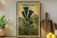 A framed illustration of blue bell flowers is displayed on a shelf, accompanied by a wooden cutting board, a potted plant, and some lemons.