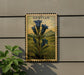 A framed illustration of blue bell flowers is displayed on a wall, with a plant to the left.