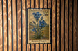 A postage stamp featuring a blue flower, labeled as a Gentian (Fringed) flower, is displayed on a wooden wall.