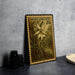 a framed stamp with a detailed illustration of a ghost orchid, placed on a table next to some black camera lenses.