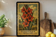 A framed illustration of a cluster of orange flowers is displayed on a shelf, accompanied by a wooden cutting board, a potted plant, and some lemons.