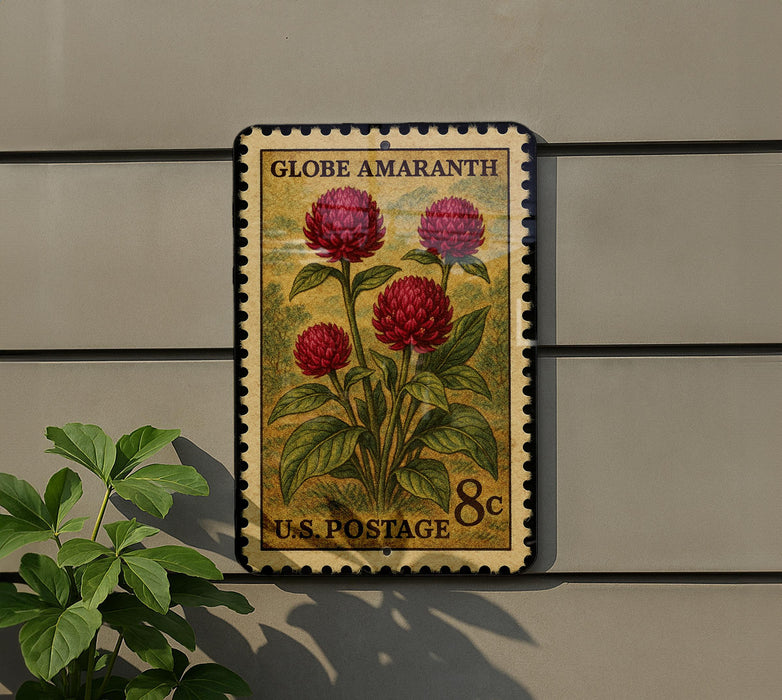 A U.S. postage stamp featuring a vibrant red flower on a green background, mounted on a wall next to a plant.
