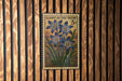A vintage postage stamp featuring a floral design is displayed on a wooden wall.