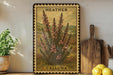 A framed illustration of a calluna plant is displayed on a shelf, accompanied by a wooden cutting board, a potted plant, and a lemon.