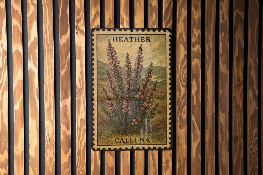 A framed image of a plant with pink flowers is displayed on a wooden wall.