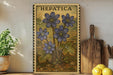 a framed print of a plant with blue flowers, placed on a shelf next to a wooden cutting board and some lemons.